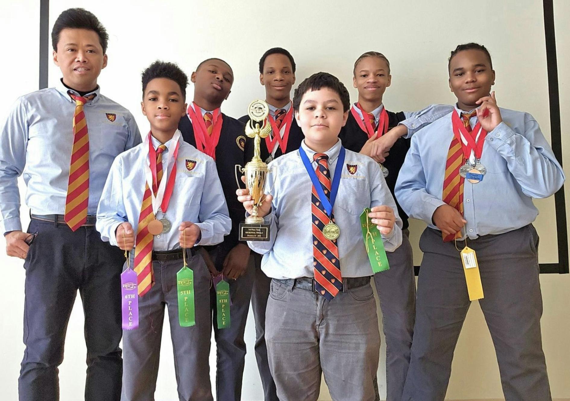 A group of young boys with medals and trophies.